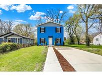 Charming blue two-story home with a well-manicured lawn and a concrete driveway at 3264 Orchard Ave, Indianapolis, IN 46218