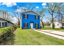 Two-story blue home featuring black shutters, a manicured lawn, and a concrete driveway at 3264 Orchard Ave, Indianapolis, IN 46218