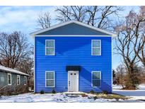 Two-story blue house with white door and gray accents, snow on ground at 3264 Orchard Ave, Indianapolis, IN 46218