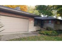 Brick ranch house with attached garage and landscaped yard at 1165 Wood Ct, Indianapolis, IN 46227