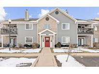 Charming multi-Gathering building with a red front door, gray siding, and well-maintained landscaping with winter snow at 12584 Tennyson Ln # 208, Carmel, IN 46032