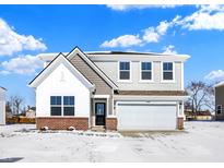 Charming two-story home features a brick base, a white-painted accent facade, and an attached two car garage at 1552 Covington Blvd, Franklin, IN 46131