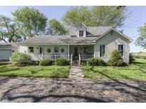 Charming home with a welcoming front porch, lush lawn, and beautiful landscaping at 4462 S Morgantown Rd, Greenwood, IN 46143