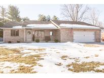 Brick ranch home with attached garage and snow-covered lawn at 965 Driftwood Ave, Columbus, IN 47203