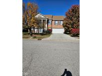Two-story brick home with attached garage and autumn landscaping at 10370 Splendor Way, Indianapolis, IN 46234