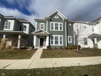 Two-story green house with a front porch and landscaping at 17389 Dallington St, Westfield, IN 46074