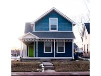 Charming two-story blue house with white trim, front porch, and a lime green door at 2502 N Harding N St, Indianapolis, IN 46208