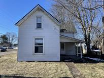 Charming white house with a gabled roof and a front porch at 30 N Muessing St, Indianapolis, IN 46229