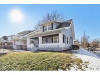 Gray house with white trim and a porch, situated on a landscaped lawn at 3558 Graceland Ave, Indianapolis, IN 46208