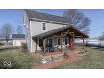 Two-story farmhouse with a large covered porch and landscaped yard at 5750 W 300 N Rd, Bargersville, IN 46106
