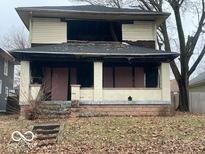 Two-story house needing complete renovation. Fire damage is visible at 622 N Temple Ave, Indianapolis, IN 46201
