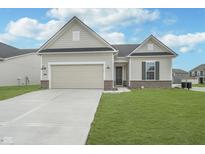 Charming single-story home with a two-car garage, well-maintained lawn, and neutral exterior paint at 7300 Legends Way, Whitestown, IN 46052