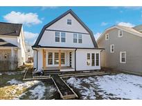 Two-story farmhouse with white siding, black accents, and a charming front porch at 923 E Pleasant Run Pkwy S Dr, Indianapolis, IN 46203