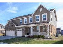 Two-story home with brick and siding exterior, three-car garage, and landscaped lawn at 9870 N Port Dr, McCordsville, IN 46055