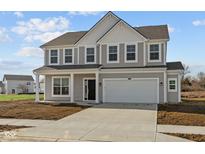 Charming two-story home featuring gray siding, white trim, a two-car garage, and a concrete driveway at 10039 Redwood Peak Ln, Indianapolis, IN 46259
