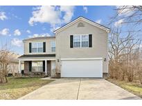 Two-story house with a white garage door and brick accents at 10237 Windchime Ct, Indianapolis, IN 46235
