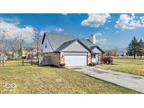 Brick ranch home with gray siding, attached garage, and landscaped lawn at 11726 E 75Th St, Indianapolis, IN 46236