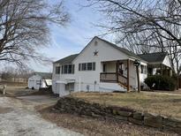 Charming two-story home with a detached garage and well-maintained landscaping at 1282 W State Road 252, Trafalgar, IN 46181