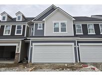 Two-story townhome with gray and beige siding, white garage door, and dormers at 18715 Moray St, Westfield, IN 46074