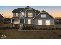 Two-story house with gray siding, brick accents, and a landscaped lawn at 4416 Voyageur Way, Carmel, IN 46074