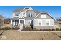 Two-story house with gray siding, brick accents, and a landscaped lawn at 4416 Voyageur Way, Carmel, IN 46074