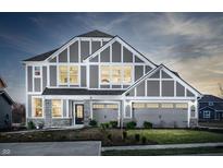 Two-story home with gray siding, stone accents, and a three-car garage at 5517 Noble Crossing W Pkwy, Noblesville, IN 46062