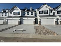 Charming townhomes showcase a crisp white facade, a private entrance, and attached garages at 7254 Shroyer Way, Noblesville, IN 46062