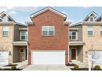 Charming townhome featuring a brick facade and attached one-car garage and modern siding at 11436 Mossy Ct # 102, Fishers, IN 46037