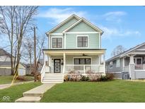 Charming two-story home featuring a welcoming front porch, well-manicured lawn, and beautiful architectural details at 1224 Keystone Ave, Indianapolis, IN 46201