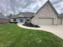 A charming brick home with a well-manicured lawn, complemented by a vibrant blue front door at 1297 Morningside Dr, Greenfield, IN 46140