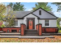 Charming brick home featuring a cozy front entry and well-manicured landscaping at 233 W Westfield Blvd, Indianapolis, IN 46208