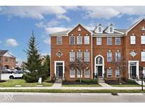 Charming brick townhome with well-maintained landscaping and inviting curb appeal on a sunny day at 335 Autumn Dr, Carmel, IN 46032