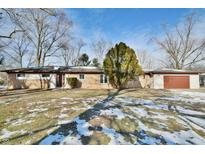 Ranch home with attached garage, situated on a spacious lot with mature trees at 4820 E 70Th St, Indianapolis, IN 46220
