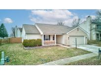 Charming home boasts a light brick facade, attached garage, and inviting front porch area at 6465 Blakeview Dr, Indianapolis, IN 46235