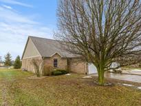 Charming single-story brick home featuring an attached garage and manicured landscaping at 101 Country Ct, Danville, IN 46122
