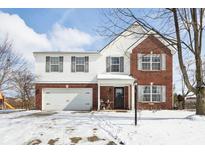 Charming two-story home featuring a brick and white facade, attached garage, and snow-covered front yard at 11020 Gresham Pl, Noblesville, IN 46060
