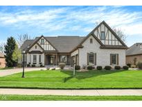 Charming light brick home with Tudor accents, lush lawn, and a welcoming curb appeal at 14565 Geist Ridge Dr, Fishers, IN 46040