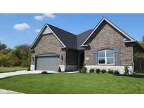 Brick house with gray garage door and landscaped lawn at 2212 Galleone Way, Plainfield, IN 46168