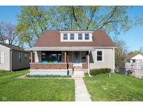 Charming home featuring a covered porch, well-maintained lawn, and inviting curb appeal at 550 Trowbridge St, Indianapolis, IN 46203