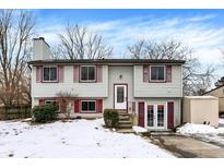 Two-story house with vinyl siding, red shutters, and a snow-covered front yard at 5715 Sage Ct, Indianapolis, IN 46237