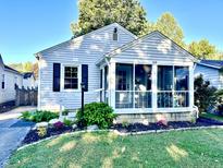 Charming one-story home with a screened porch and well-manicured lawn at 6118 Evanston Ave, Indianapolis, IN 46220