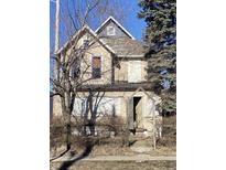 Two-story home needing renovation, featuring boarded windows and a weathered exterior at 724 E 22Nd St, Indianapolis, IN 46202