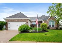 Charming brick home featuring a well-manicured lawn, tidy landscaping, and an attached two car garage at 8535 Blue Marlin Dr, Indianapolis, IN 46239