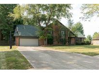 Brick house with green roof, attached garage, and basketball hoop at 877 Revere Ct, Greenwood, IN 46142