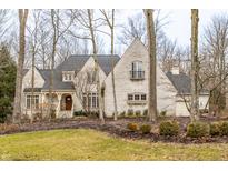 Charming two-story brick home featuring a manicured lawn and mature trees at 9399 Irishmans Run Ln, Zionsville, IN 46077