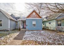 Charming craftsman-style home with light blue siding and a pink door at 957 W Roache St, Indianapolis, IN 46208