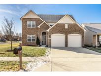 Inviting two-story brick home with a well-manicured lawn, two-car garage, and classic architectural design at 10917 Hunter Lake Ln, Indianapolis, IN 46239