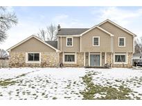 Two-story house with stone and siding, a partially snow-covered lawn, and a driveway at 1271 Spruce Dr, Carmel, IN 46033