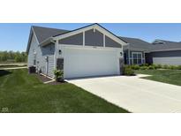 Charming home with a spacious two-car garage and concrete driveway, surrounded by well-manicured lawn and landscaping at 19438 Astoria Ave, Sheridan, IN 46069