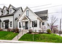 Charming two-story home with white siding, black trim, landscaped yard, and inviting front porch at 2301 Nowland Ave, Indianapolis, IN 46201
